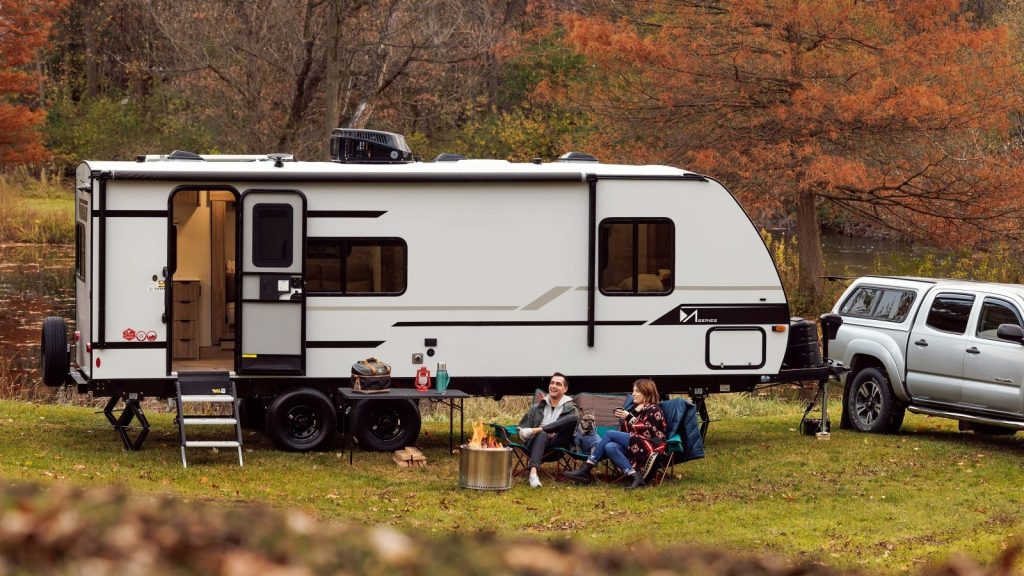 Couple sitting outside their travel trailer