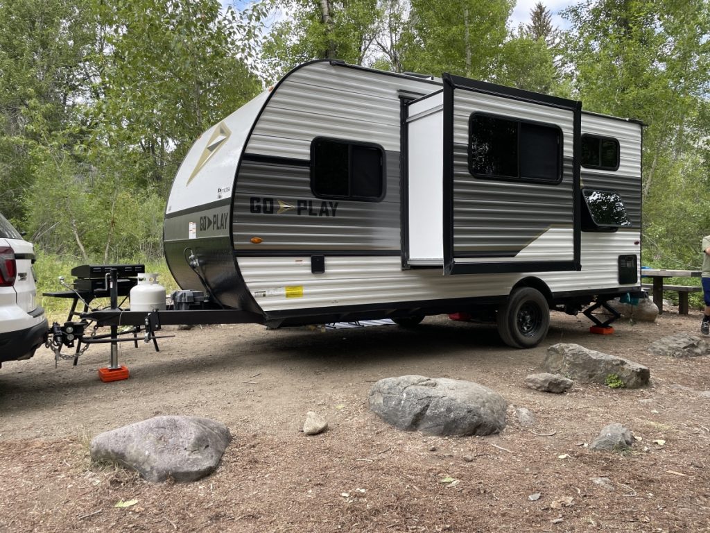 Towable RV with slides out at campsite 