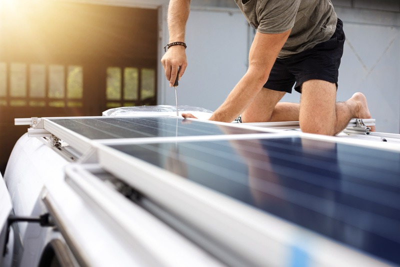 guy on roof of rv installing solar