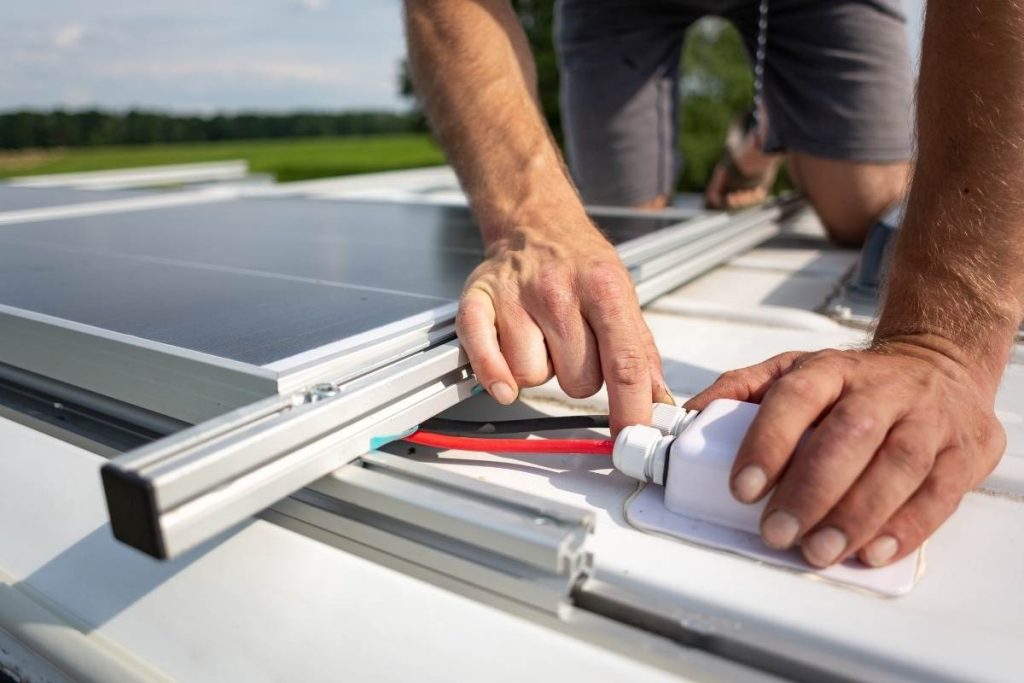 close up of hands installing solar power on rv