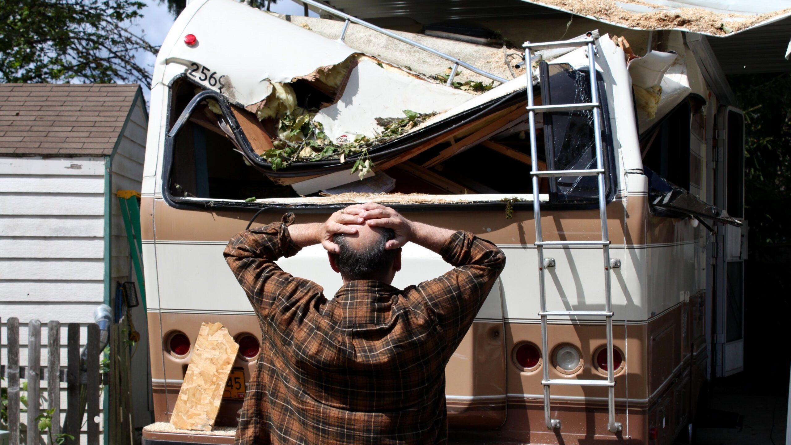 Man staring at his RV crushed by a branch