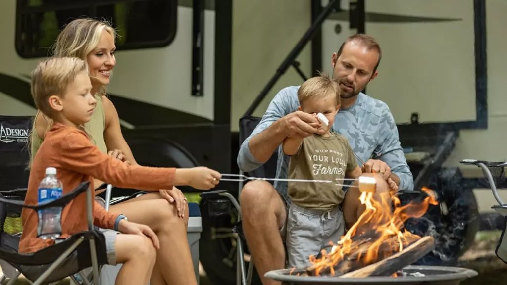 family roasting marshmallows outside 5th wheel