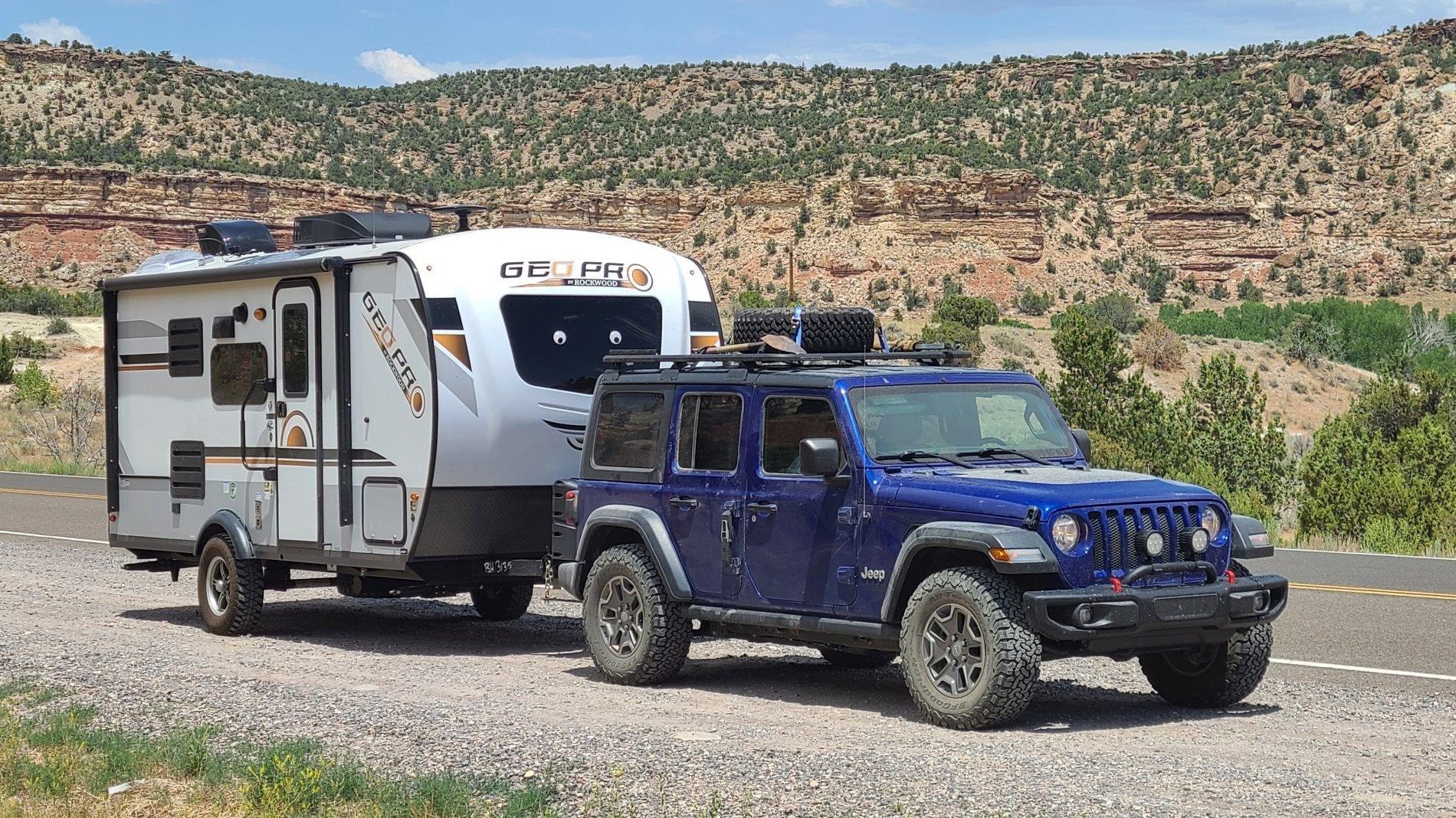 blue jeep towing a geo pro rv