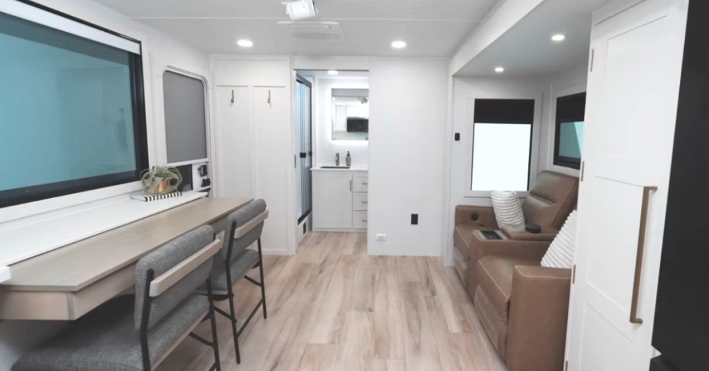 Spacious living area in Brinkley Model I RV with 62-inch reclining theater sofa and entertainment-ready setup