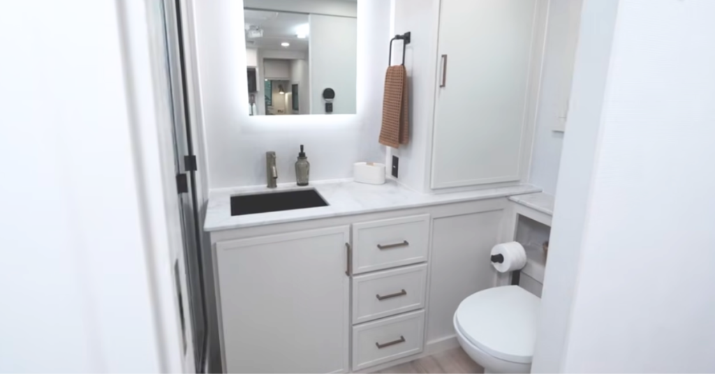 Residential-style bathroom in Brinkley Model I RV with porcelain toilet and ample counter and storage space