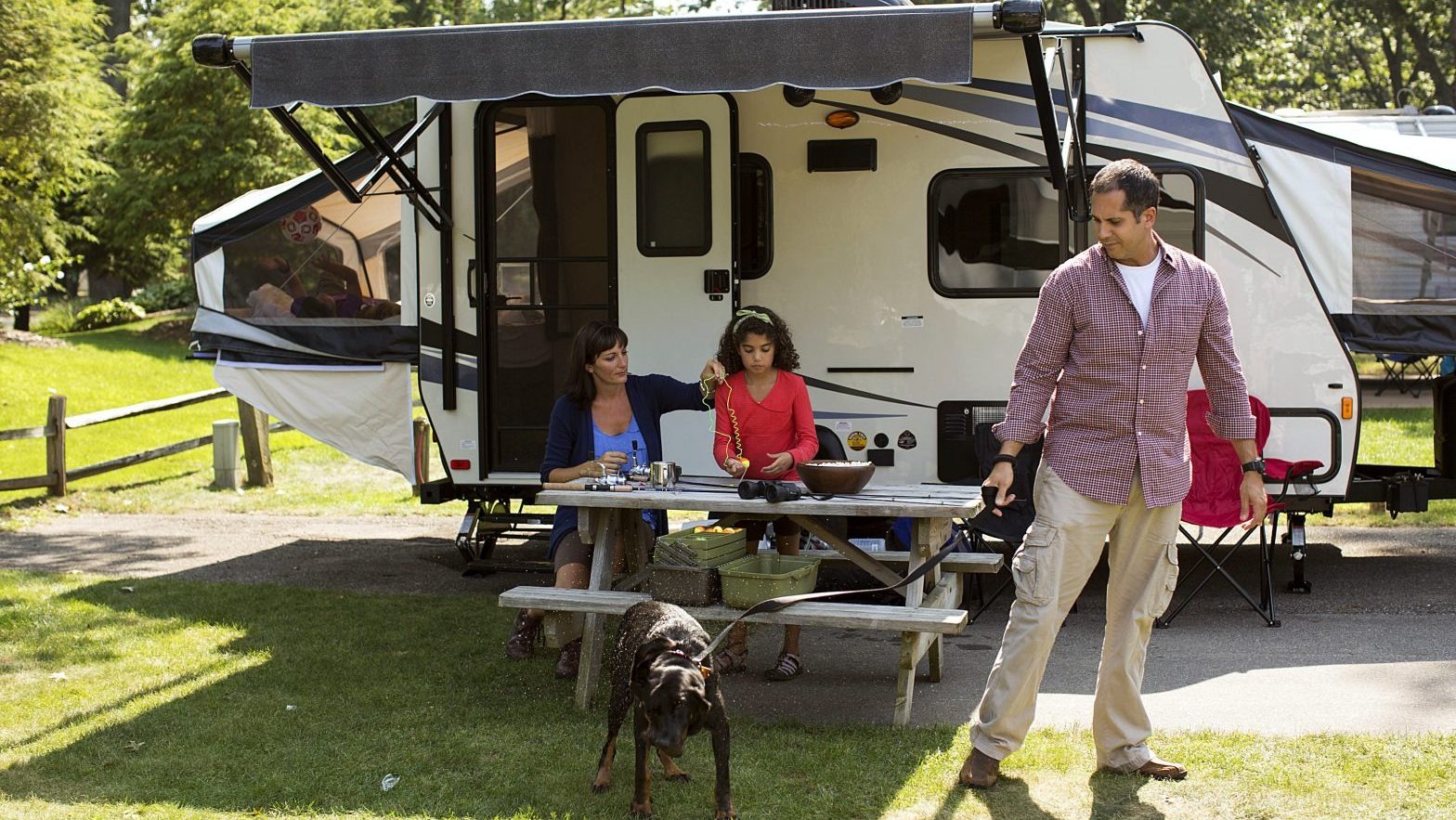 Family outside a small camper