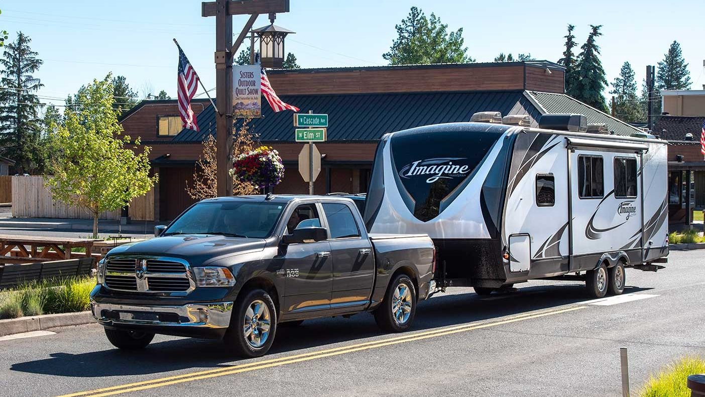 Truck towing Grand Design Imagine on city Street