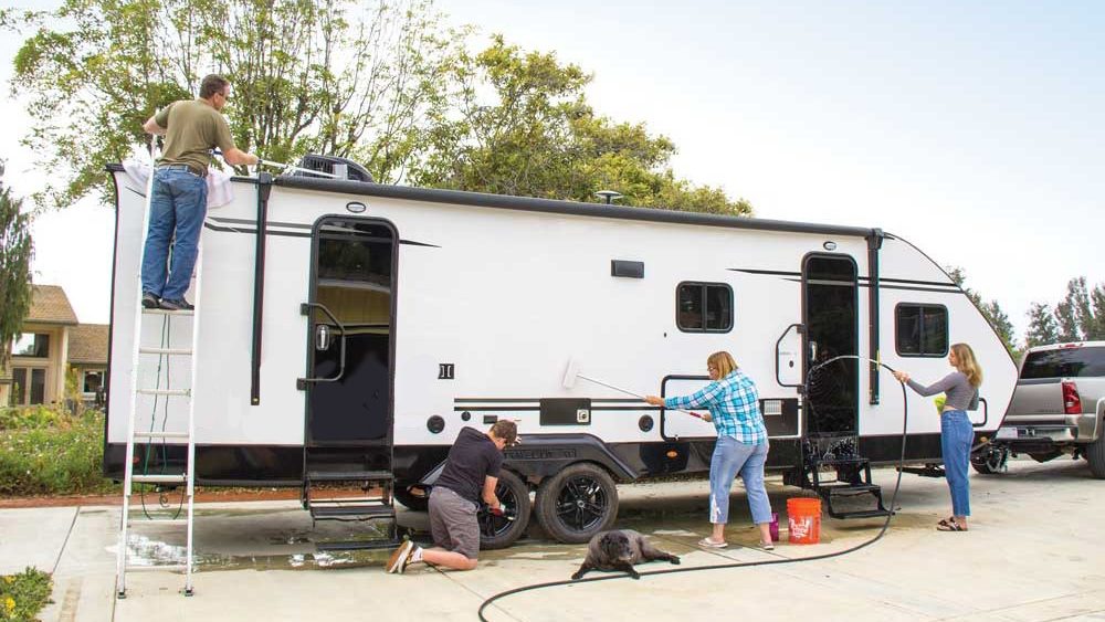 family washing their travel trailer